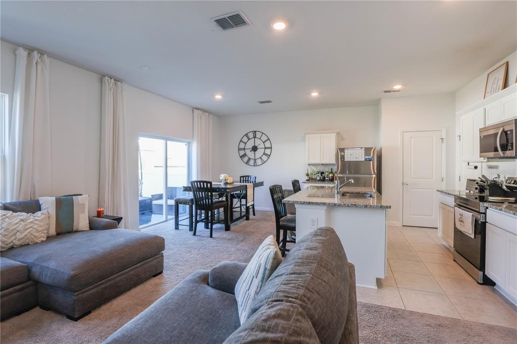 2240 Hemingway Circle Groveland, FL 34736 - Photo 8 of 34 a living room with furniture kitchen view and a large window