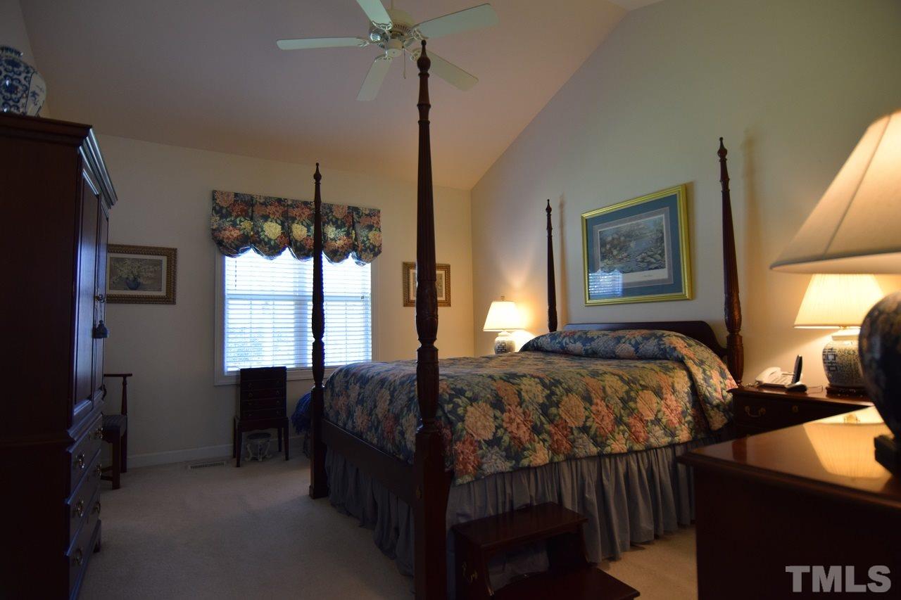 6404 Nowell Pointe Drive Raleigh, NC 27607 - Photo 11 of 24 a bedroom with a bed window and a flat tv screen