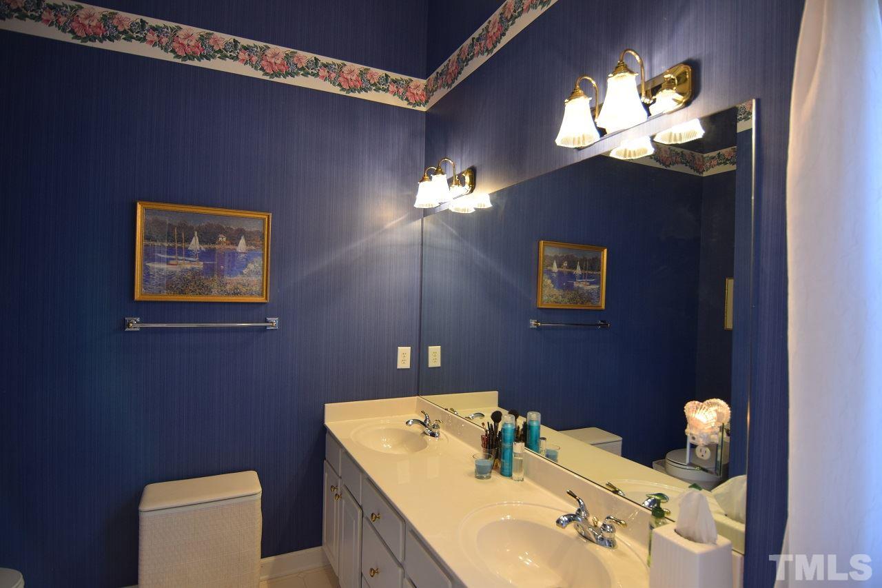 6404 Nowell Pointe Drive Raleigh, NC 27607 - Photo 14 of 24 a bathroom with a sink mirror and vanity