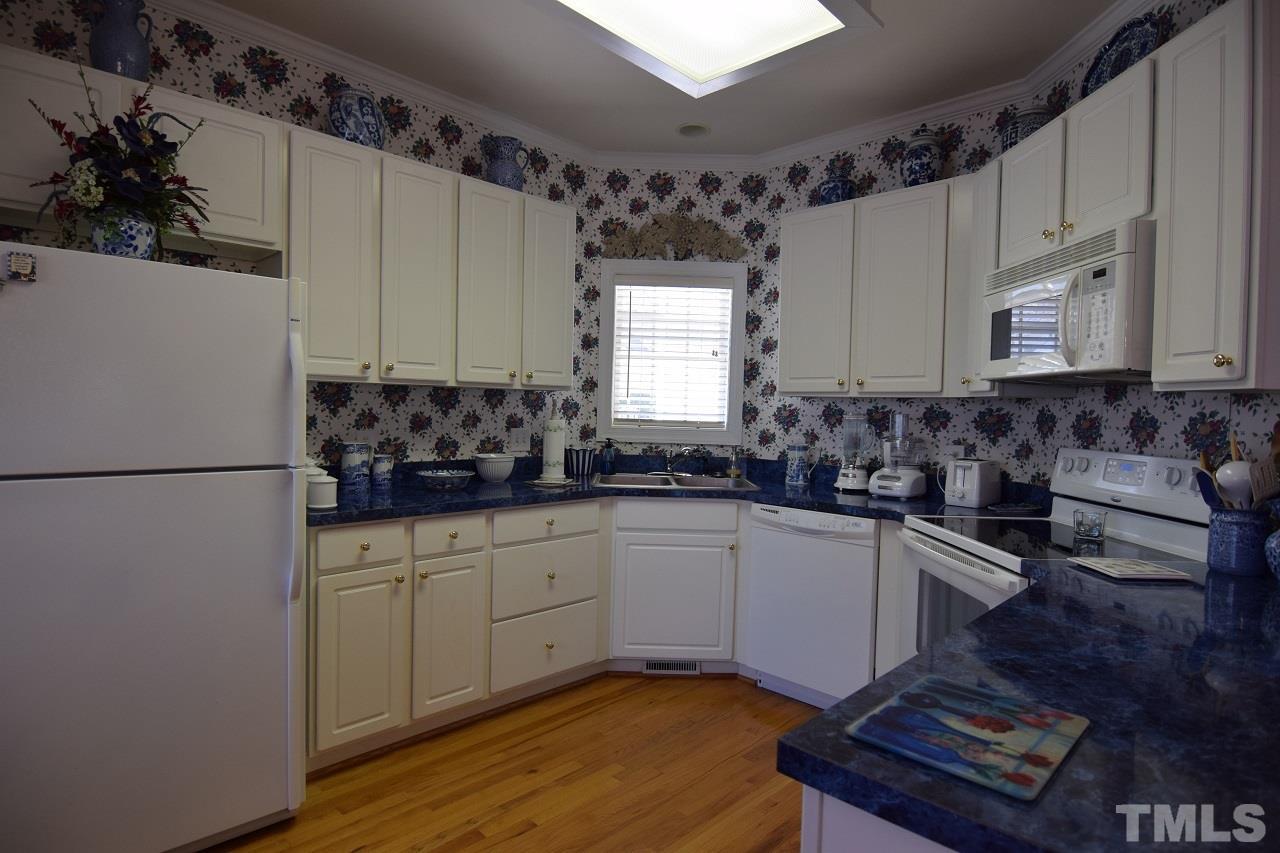 6404 Nowell Pointe Drive Raleigh, NC 27607 - Photo 4 of 24 a kitchen with granite countertop a sink stainless steel appliances and cabinets