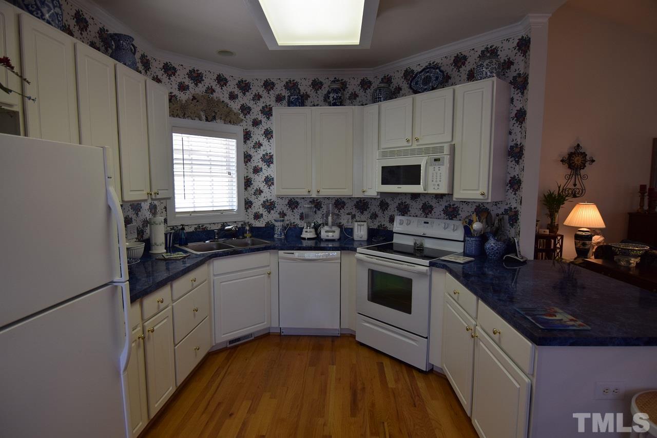 6404 Nowell Pointe Drive Raleigh, NC 27607 - Photo 5 of 24 a kitchen with a sink stove and cabinets