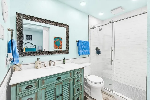 a bathroom with a sink vanity mirror and toilet