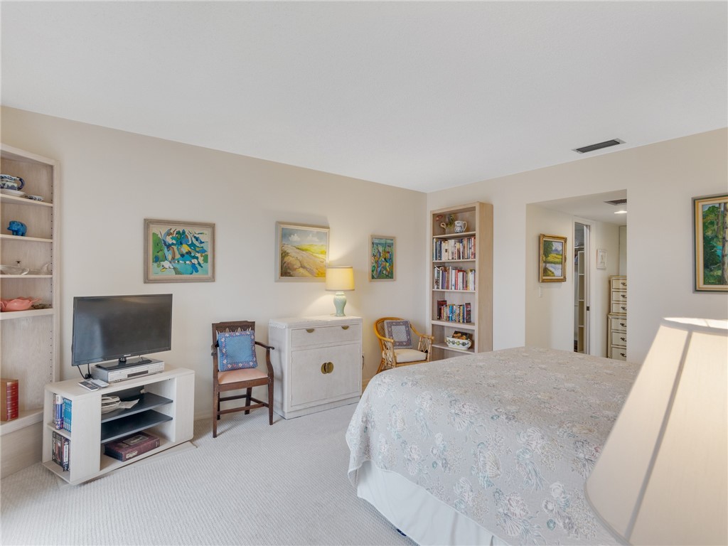 1880 Bay Road, Unit I319 Vero Beach, FL 32963 - Photo 20 of 36 a bedroom with a bed and a flat screen tv