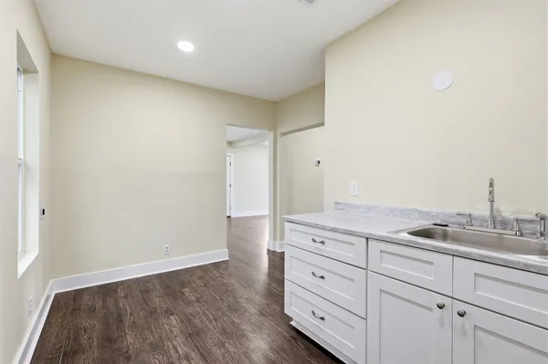 a kitchen with granite countertop white cabinets and sink