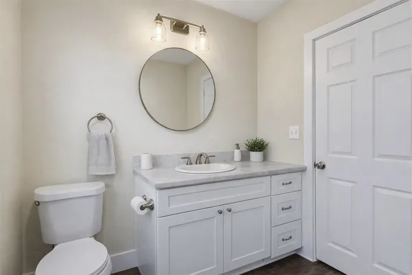 a bathroom with a toilet sink and mirror