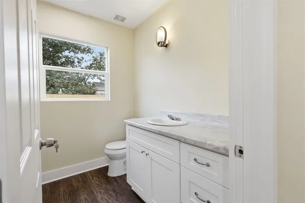 a bathroom with a granite countertop sink mirror vanity and toilet