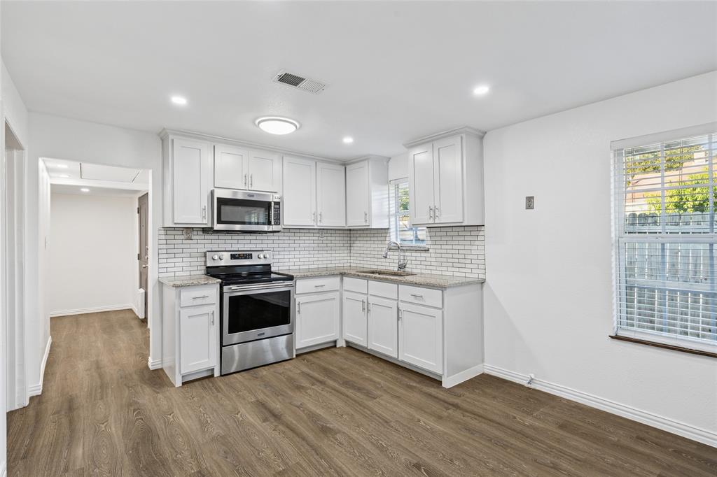 3000 Burchill Road South Fort Worth, TX 76105 - Photo 10 of 26 a kitchen with granite countertop white cabinets and stainless steel appliances