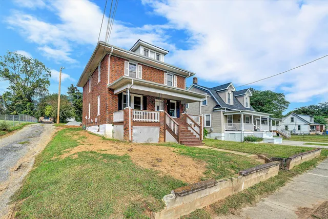 a view of a white house with a big yard and large trees