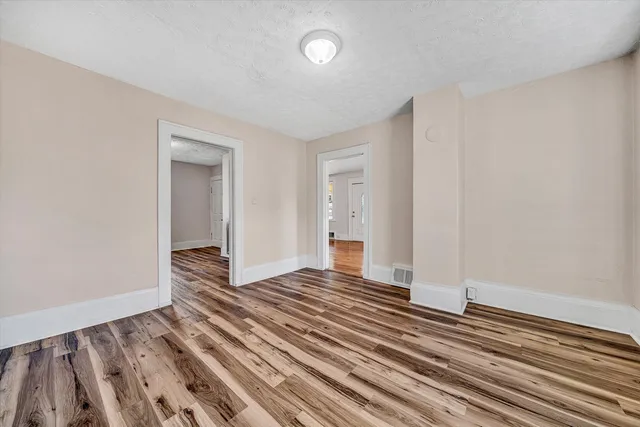 a kitchen that has a sink wooden floor and stainless steel appliances