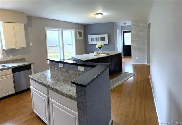 a kitchen with kitchen island granite countertop a sink a counter top space and appliances