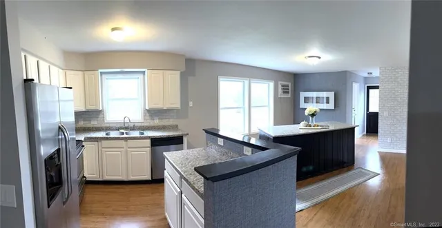 a kitchen with granite countertop a sink stove and refrigerator