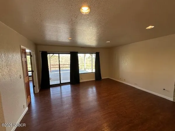 an empty room with wooden floor and fireplace
