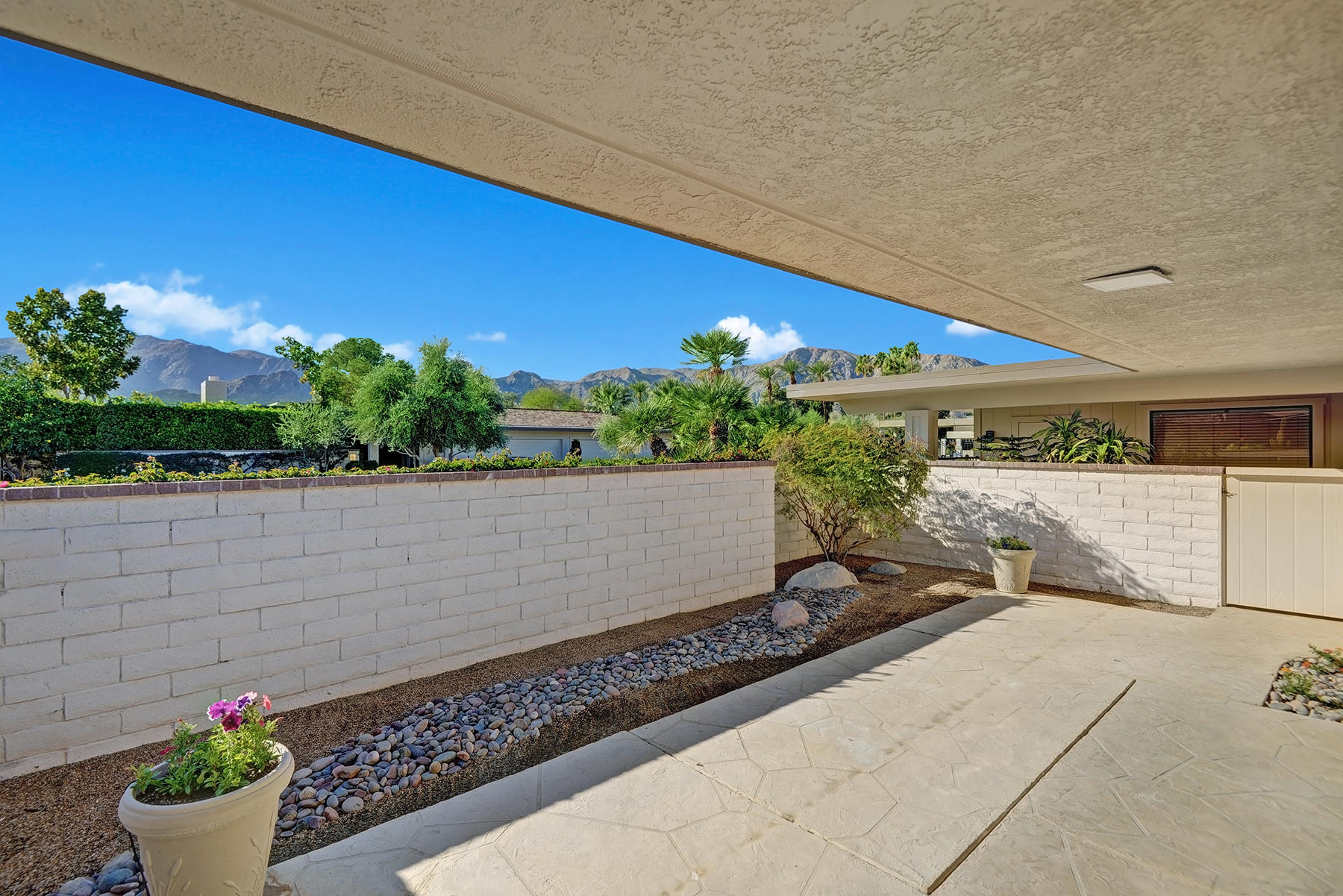34 Duke Drive Rancho Mirage, CA 92270 - Photo 31 of 32 a view of a street with flower plants and wooden fence
