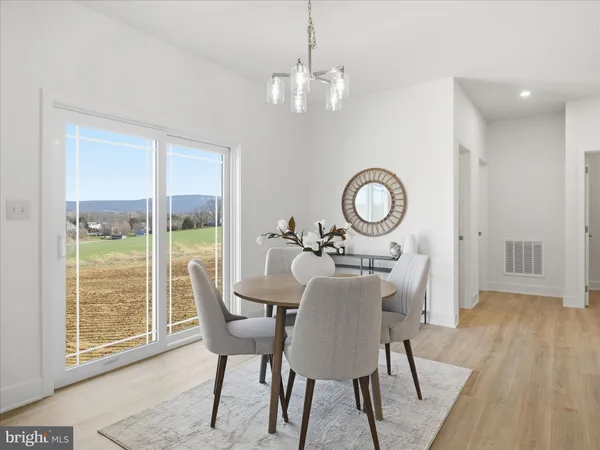 a dining room with furniture a chandelier and wooden floor
