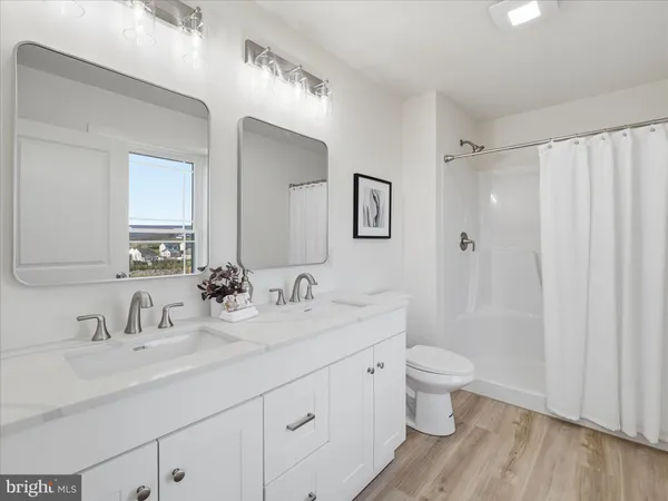 a bathroom with a double vanity sink a toilet and a mirror
