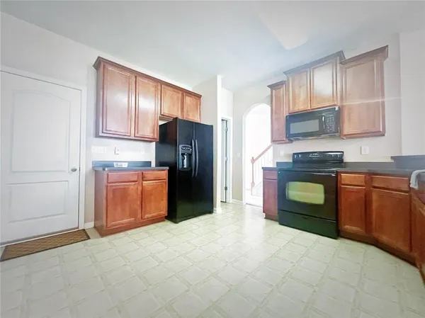 a kitchen with stainless steel appliances granite countertop a refrigerator stove and sink