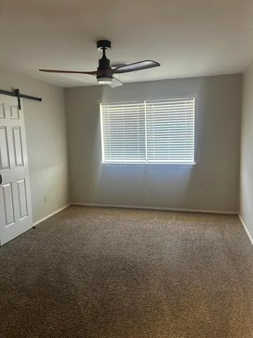 a view of a livingroom with a ceiling fan and window