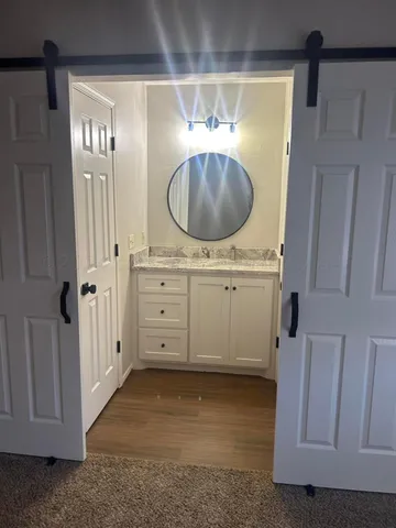 a view of a hallway with entryway cabinet and cabinet