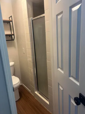 a bathroom with a granite countertop shower and a toilet