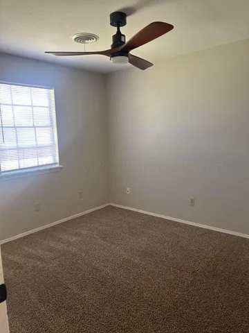 an empty room with a ceiling fan and windows