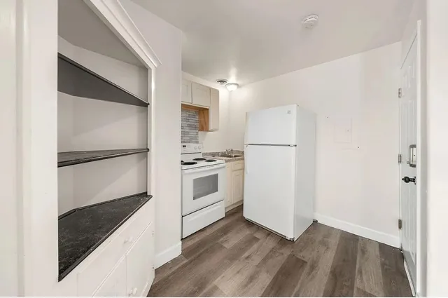 a kitchen with white cabinets and white appliances