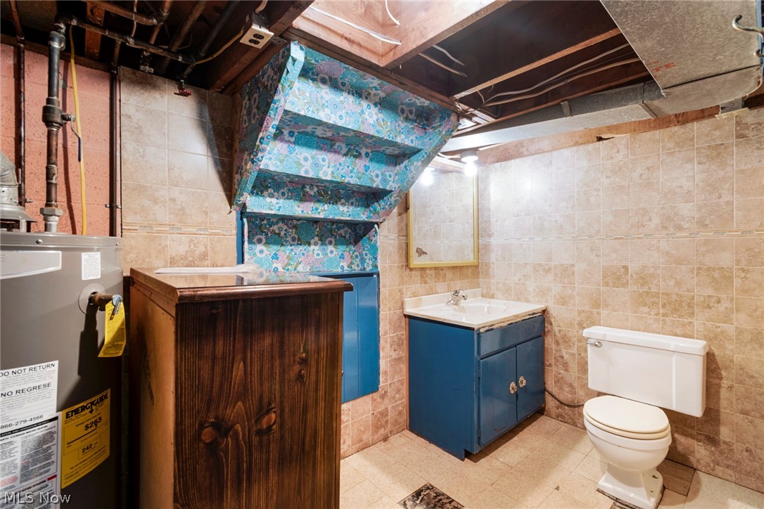 550 Edison Street Struthers, OH 44471 - Photo 18 of 23 Bathroom with tile patterned flooring, toilet, vanity, tile walls, and water heater