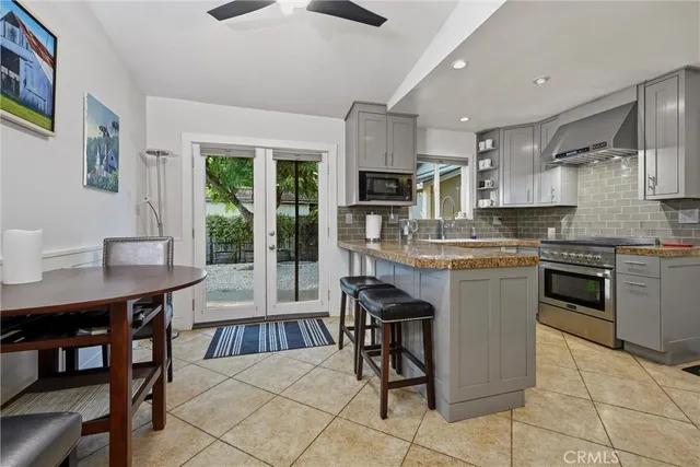 a kitchen with stainless steel appliances kitchen island granite countertop a stove and cabinets