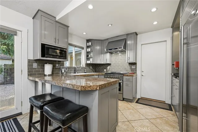 a kitchen with granite countertop a table chairs microwave and cabinets