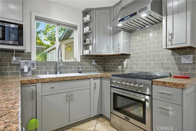 a kitchen with stainless steel appliances granite countertop a stove refrigerator and a microwave