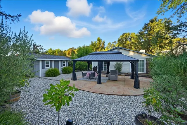 a view of a patio with couches potted plants and floor to ceiling window