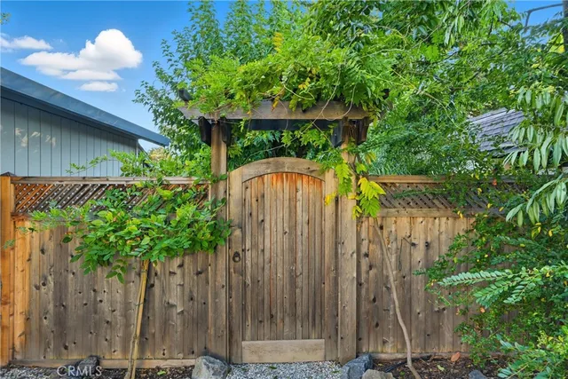 a view of a house with potted plants and large trees
