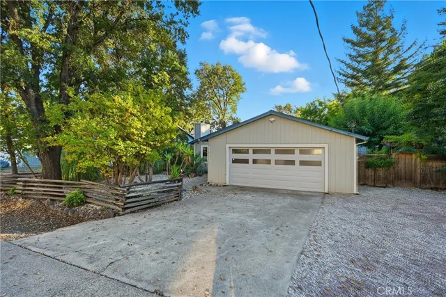 a view of a house with a yard and large tree