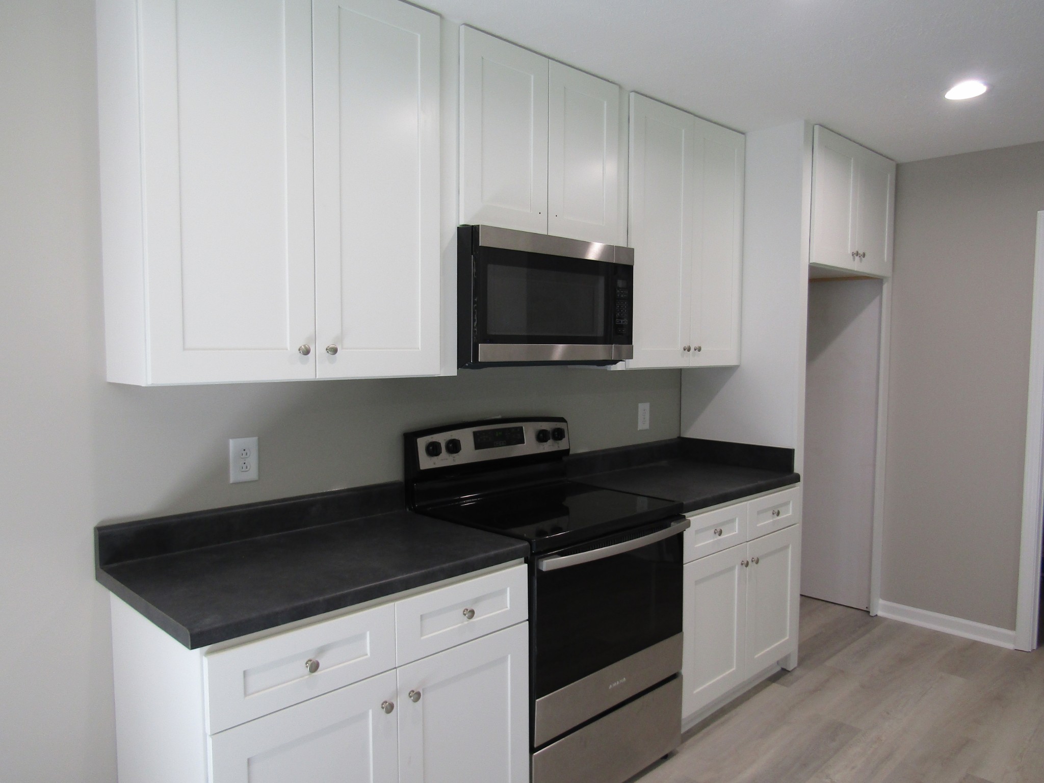 308 Ostella Road Cornersville, TN 37047 - Photo 10 of 19 a kitchen with granite countertop white cabinets and black appliances