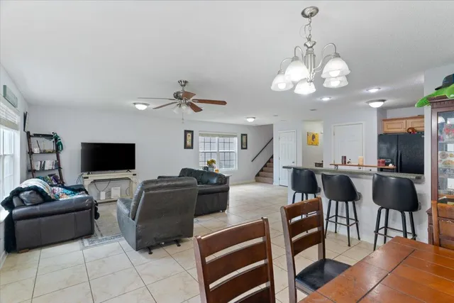 a living room with furniture a flat screen tv and kitchen view