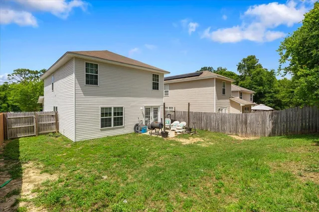 a backyard of a house with table and chairs