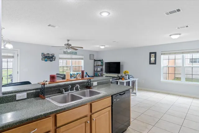 a kitchen with a sink a counter top space and stainless steel appliances