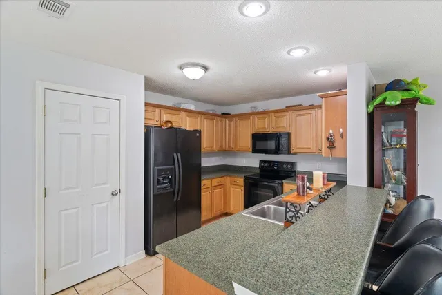 a kitchen with stainless steel appliances granite countertop a refrigerator stove top oven a sink and dishwasher