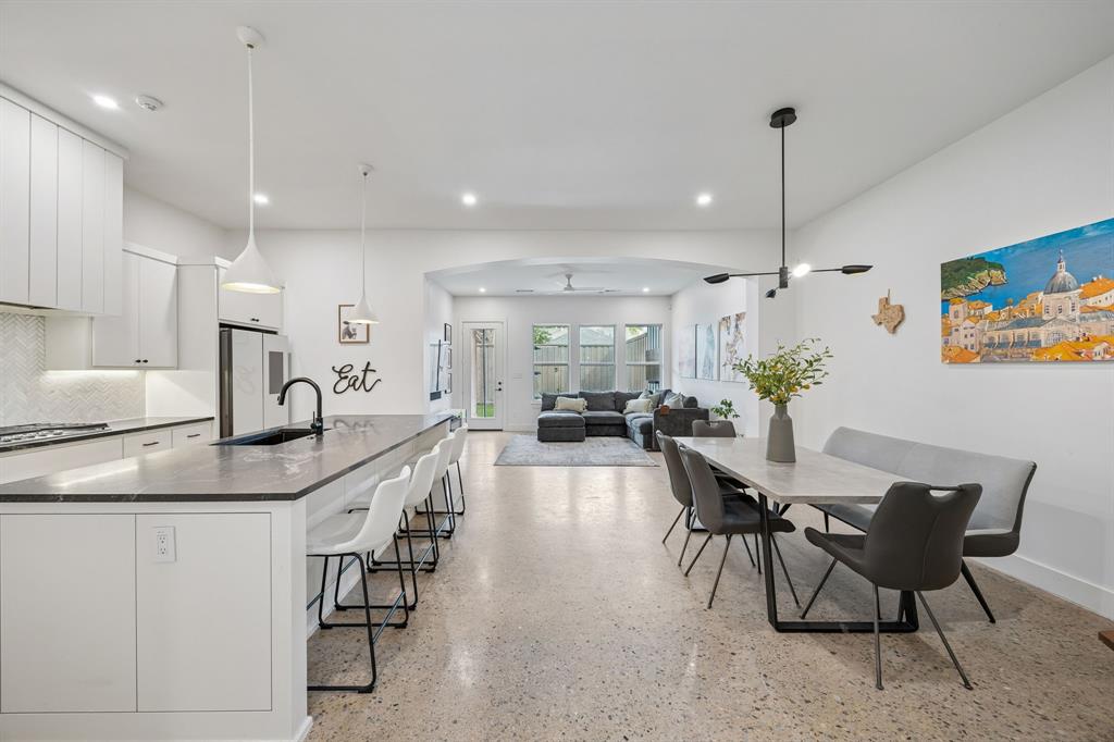 5104 Vandelia Street Dallas, TX 75235 - Photo 1 of 40 a kitchen with stainless steel appliances kitchen island granite countertop a table chairs and a refrigerator