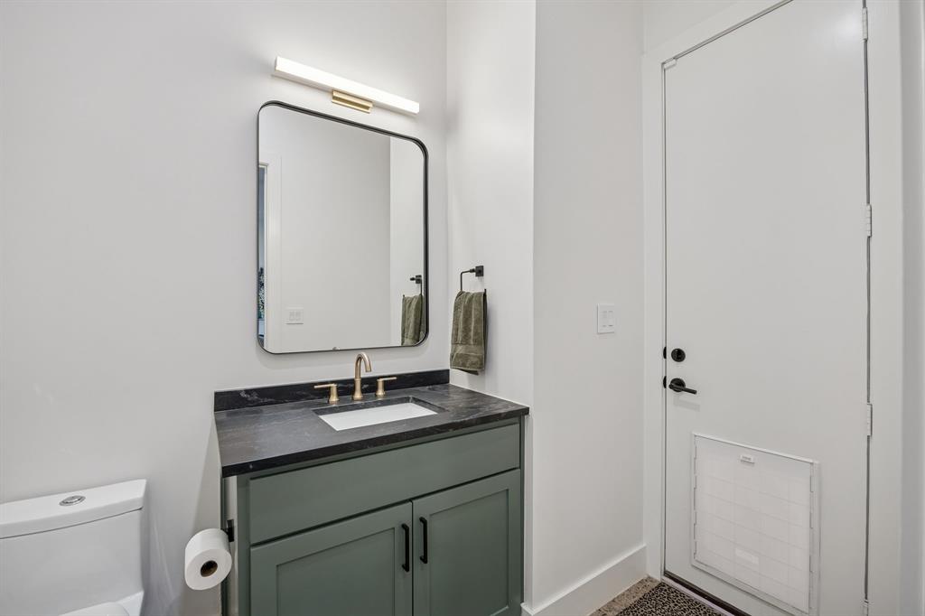 5104 Vandelia Street Dallas, TX 75235 - Photo 15 of 40 a bathroom with a sink a toilet and mirror