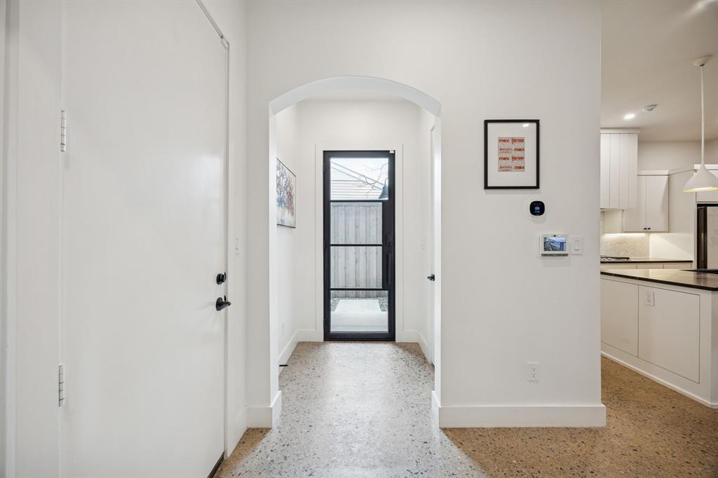 5104 Vandelia Street Dallas, TX 75235 - Photo 16 of 40 a view of a hallway with white cabinets and wooden floor