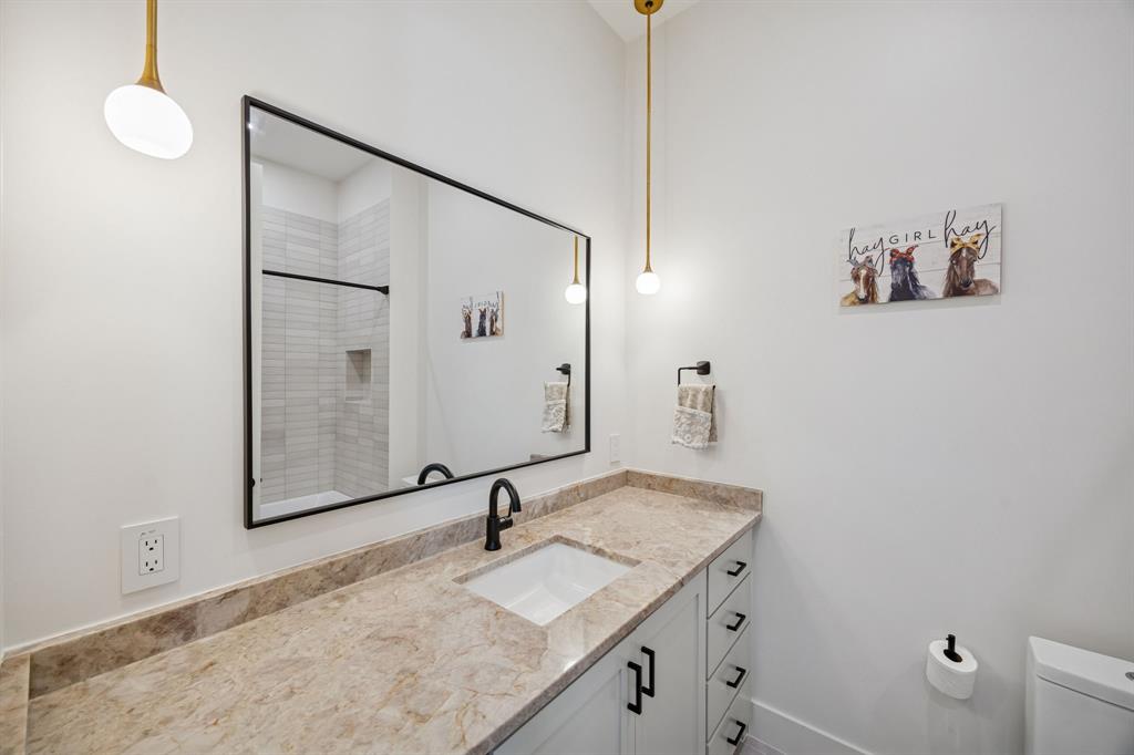 5104 Vandelia Street Dallas, TX 75235 - Photo 25 of 40 a bathroom with a granite countertop sink a mirror and shower