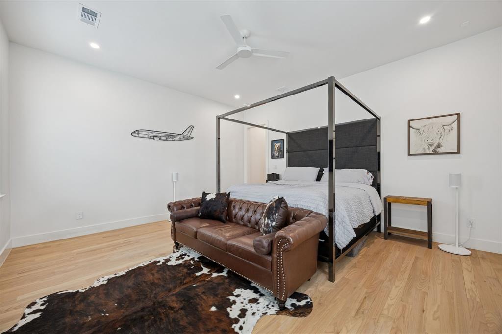 5104 Vandelia Street Dallas, TX 75235 - Photo 30 of 40 a spacious bedroom with a bed and wooden floor