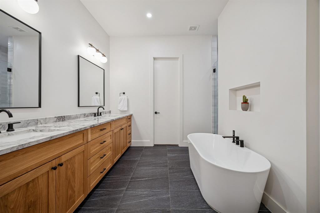 5104 Vandelia Street Dallas, TX 75235 - Photo 32 of 40 a spacious bathroom with a double vanity sink double mirror and bathtub