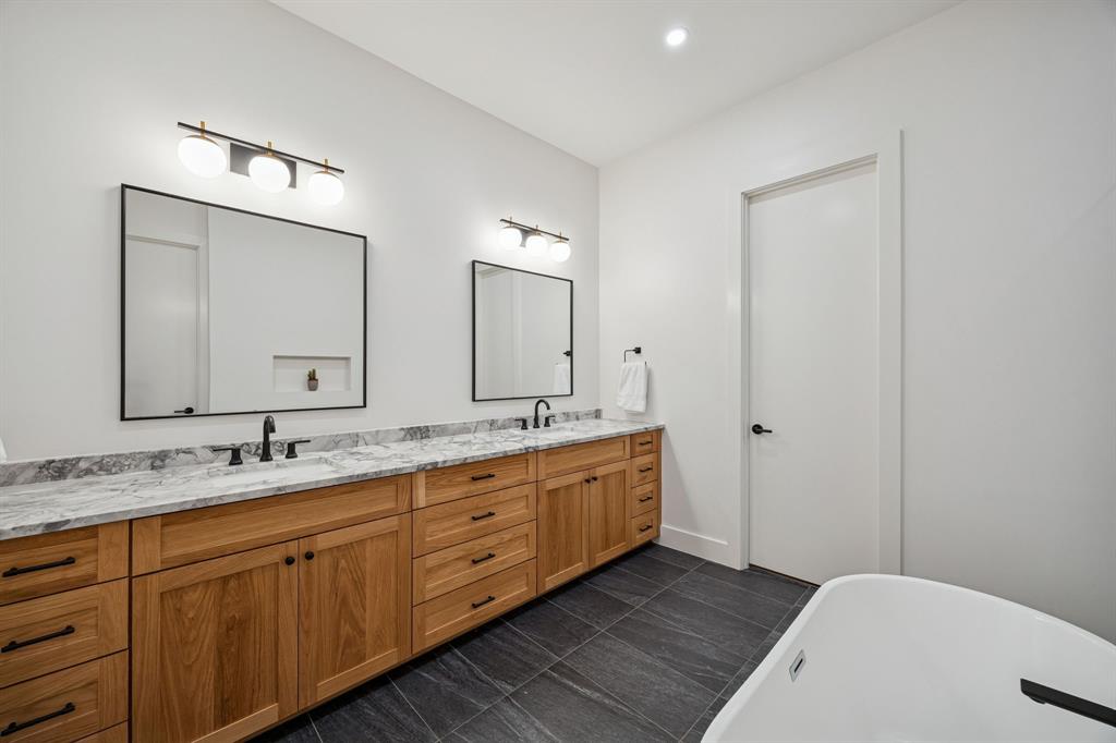 5104 Vandelia Street Dallas, TX 75235 - Photo 33 of 40 a spacious bathroom with a double vanity sink and a mirror