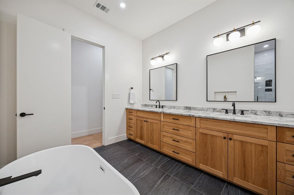 5104 Vandelia Street Dallas, TX 75235 - Photo 34 of 40 a spacious bathroom with a double vanity sink and mirror