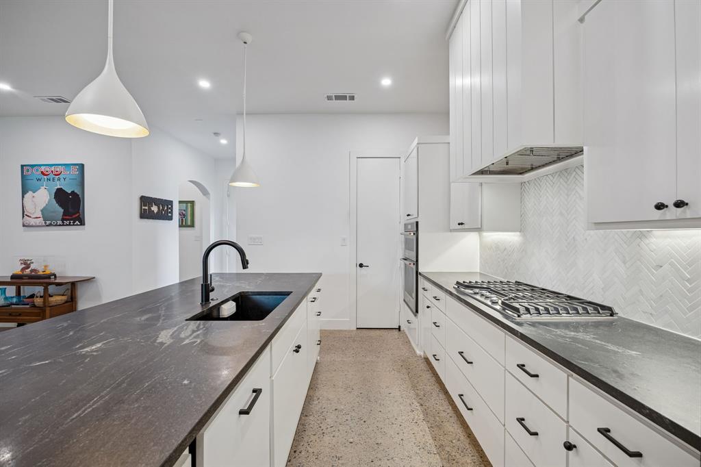 5104 Vandelia Street Dallas, TX 75235 - Photo 8 of 40 a kitchen with sink a stove and cabinets