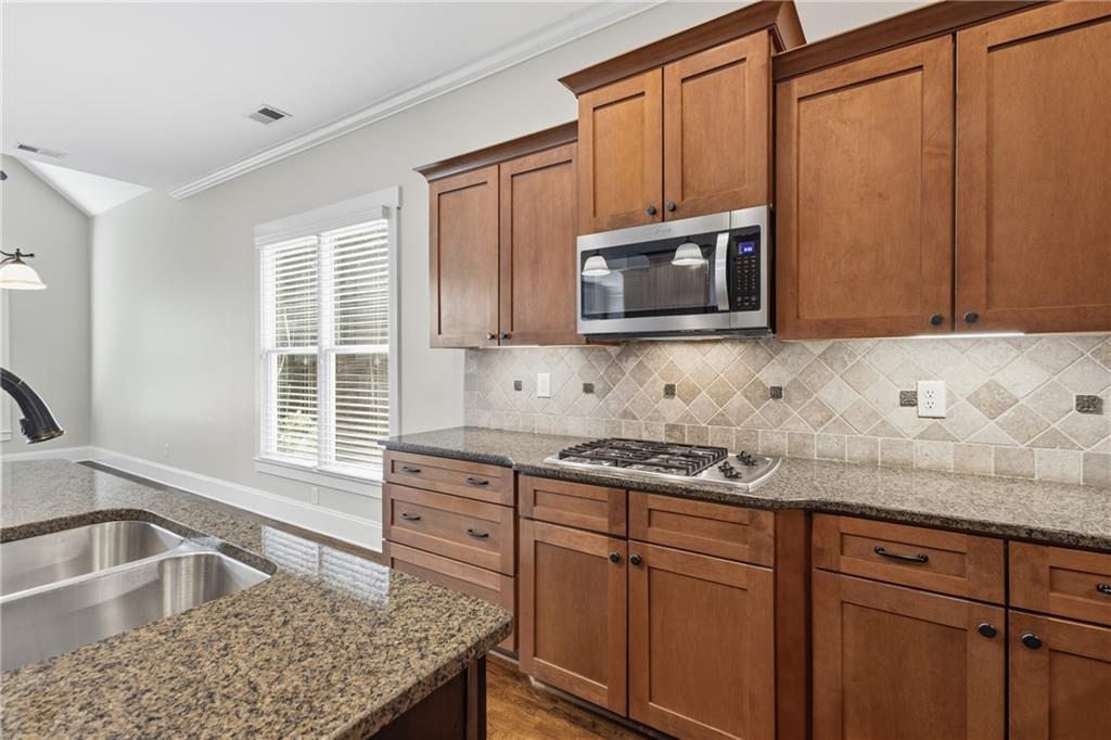 4340 Silent Path Cumming, GA 30028 - Photo 17 of 47 a kitchen with granite countertop stainless steel appliances a sink stove and microwave