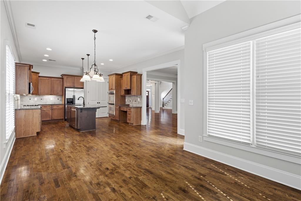 4340 Silent Path Cumming, GA 30028 - Photo 20 of 47 a kitchen with stainless steel appliances refrigerator wooden floor dining table and chairs