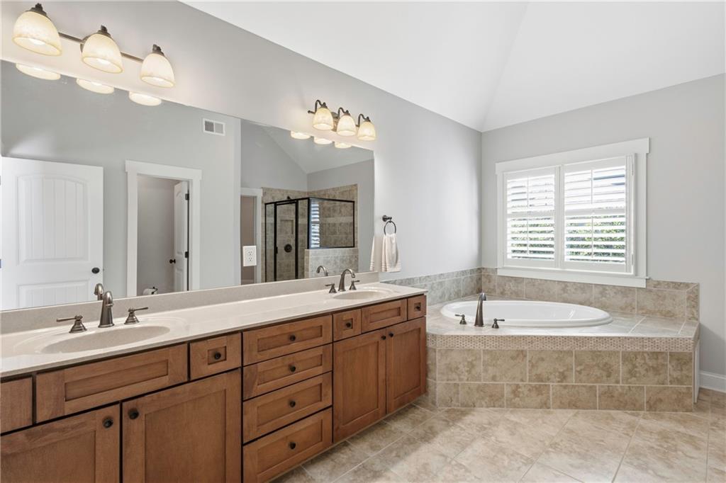 4340 Silent Path Cumming, GA 30028 - Photo 28 of 47 a spacious bathroom with a tub double sink and mirror