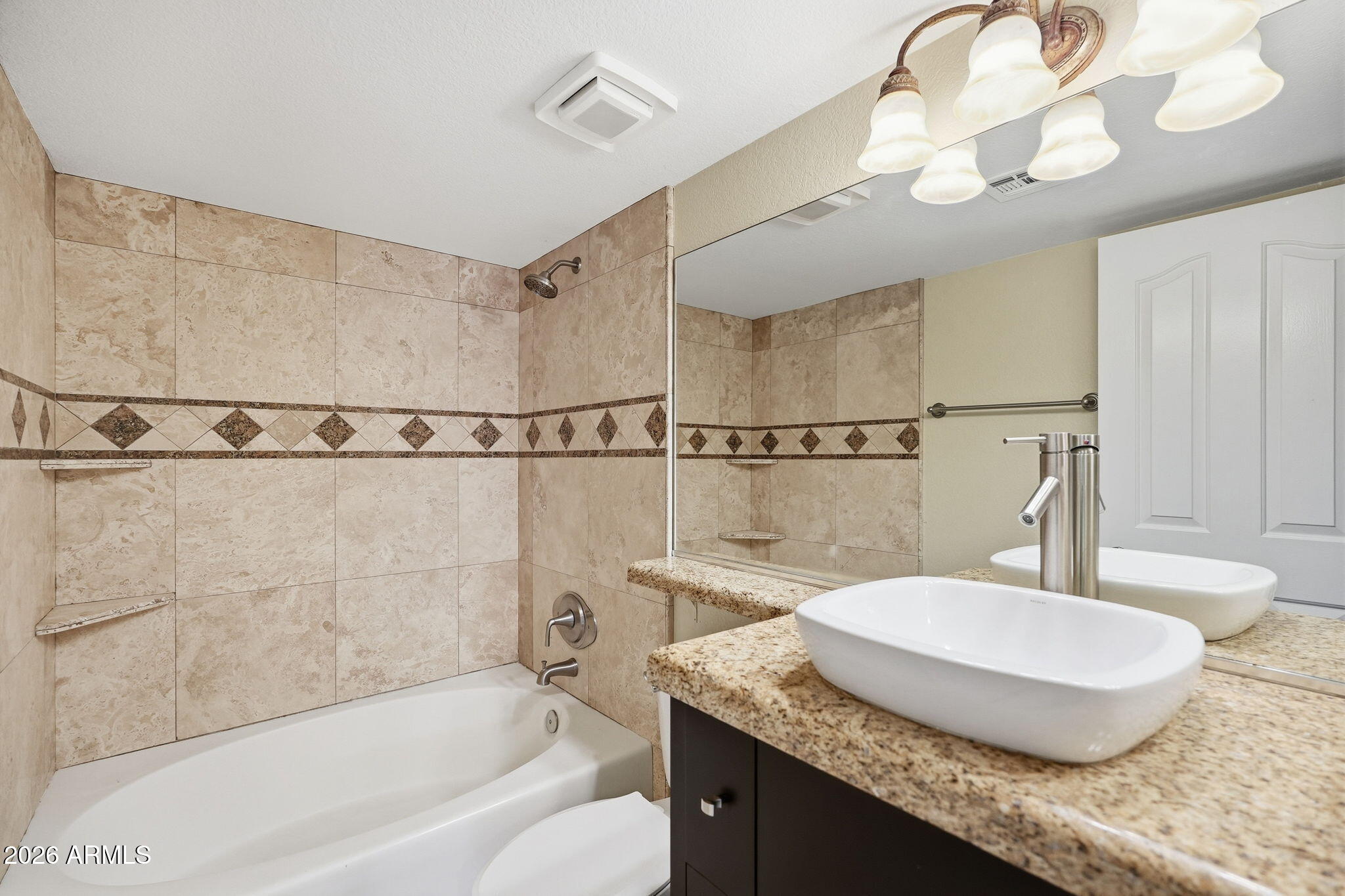 3235 East Camelback Road, Unit 211 Phoenix, AZ 85018 - Photo 9 of 17 a bathroom with a granite countertop sink a mirror and a bathtub